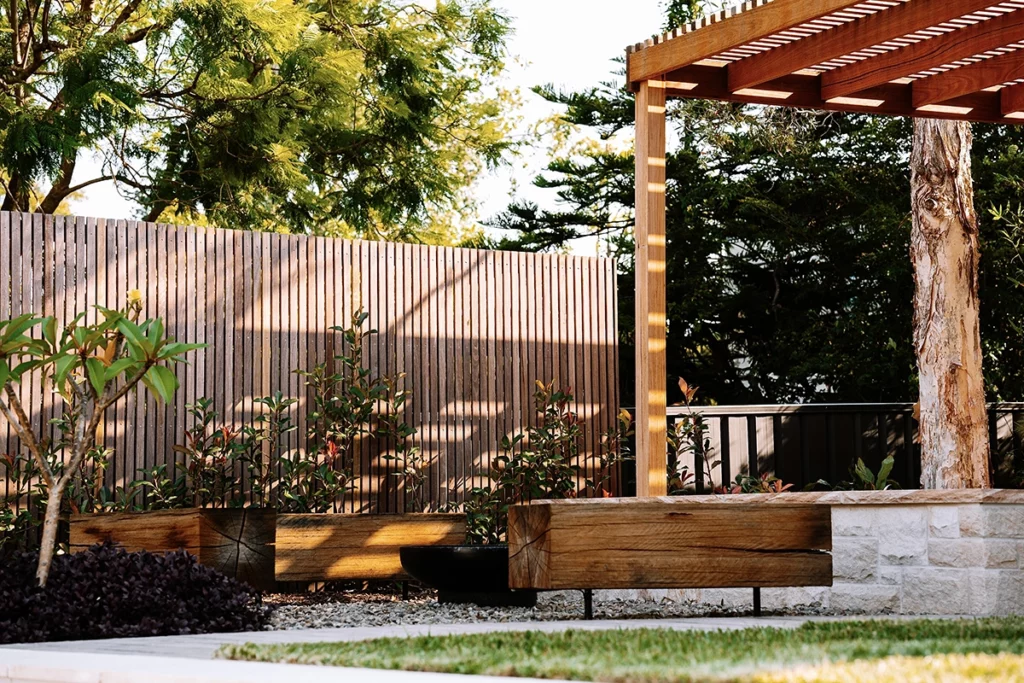 timber pergola next to wood cladded fence